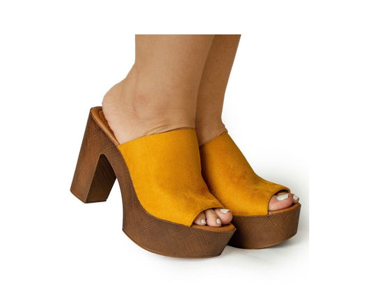 Mustard yellow high-heeled sandals on a white background