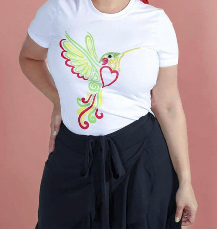 Person wearing a white t-shirt with a colorful hummingbird design on a pink background