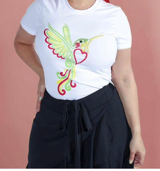 Person wearing a white t-shirt with a colorful hummingbird design on a pink background