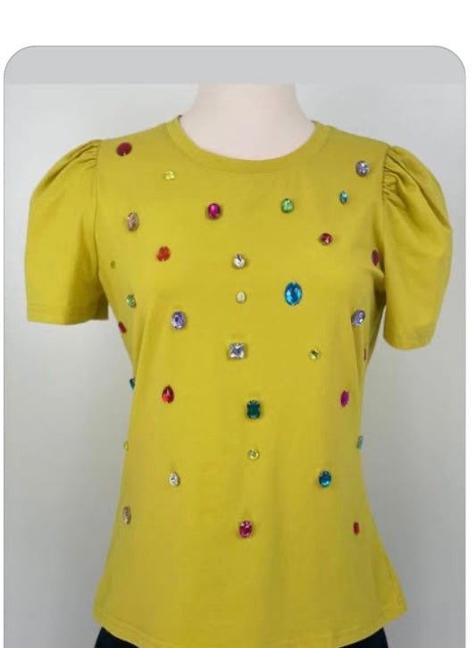 Yellow blouse with colorful embellishments on a mannequin against a gray background
