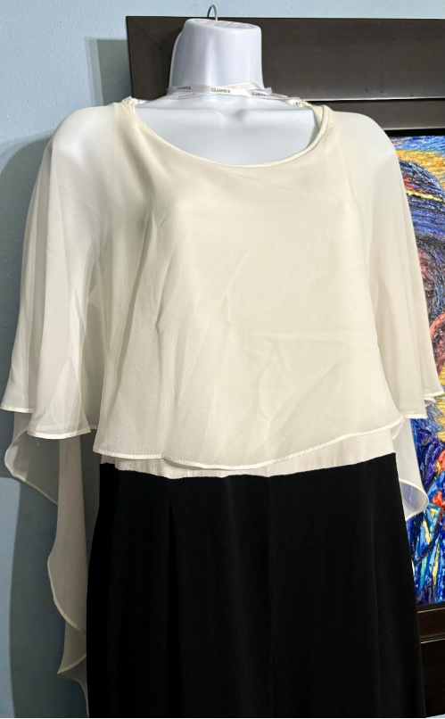 White blouse with sheer sleeves on a mannequin against a colorful abstract painting.